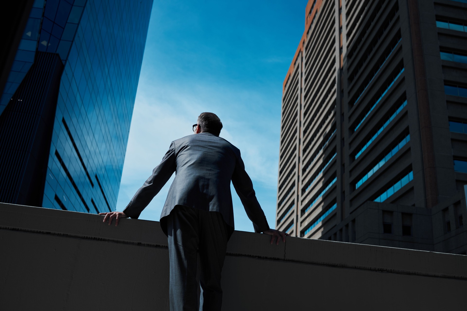 Shot of a mature businessman leaning his arms against a wall in the city